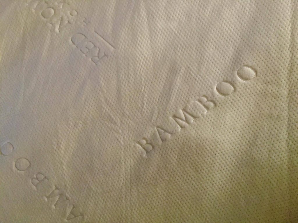 Red Nomad Mattress Protector on Bed Closeup
